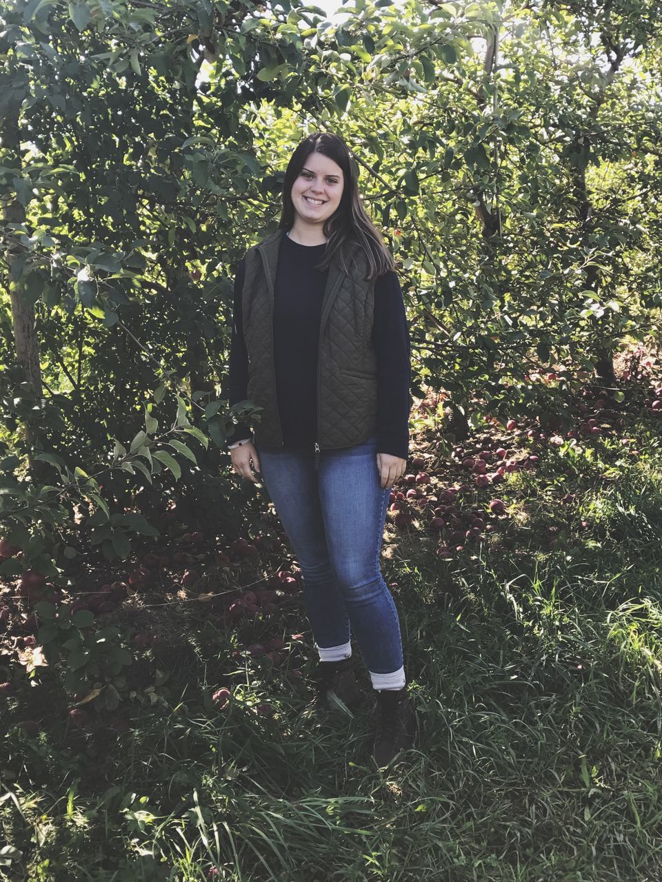 young adult, one person, young women, casual clothing, full length, standing, growth, plant, front view, day, looking at camera, real people, tree, portrait, leisure activity, smiling, outdoors, beautiful woman, nature, lifestyles, happiness, one young woman only, grass, people