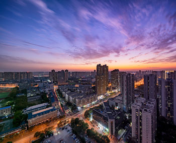 High angle view of illuminated buildings against sky during sunset