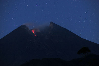 Scenic view of volcanic mountain against sky at night