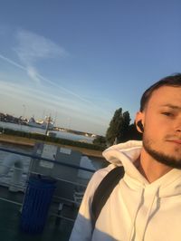 Portrait of young man in boat against sky