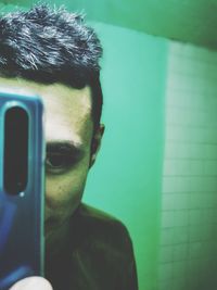 Close-up portrait of young man using mobile phone