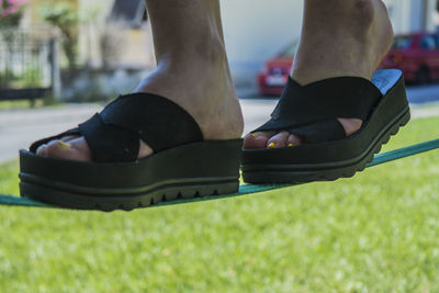 Low section of man wearing shoes on grass