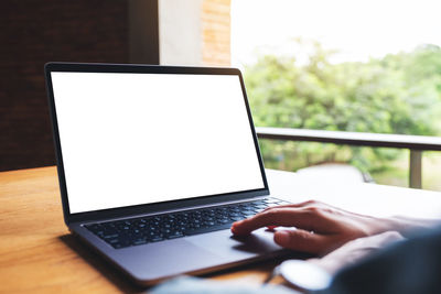 Cropped hands using laptop on table