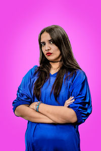 Young woman standing against yellow background