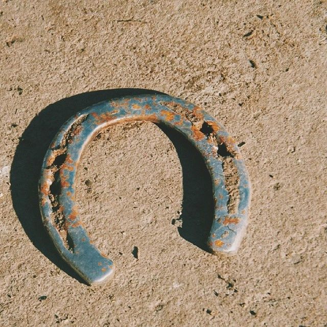 sand, beach, high angle view, circle, communication, text, shore, close-up, day, heart shape, outdoors, western script, no people, sunlight, creativity, geometric shape, ideas, street, blue, textured