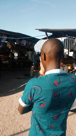 Rear view of man standing against built structure