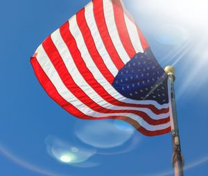 Low angle view of flag against clear blue sky