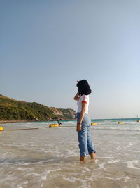 Full length of boy on beach against clear sky