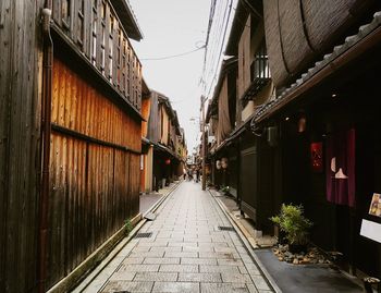 Alley amidst street in city against sky