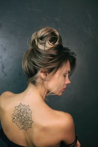 Rear view of woman with tattoo on back