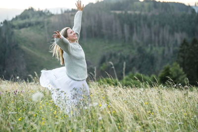 Rear view of woman standing on field