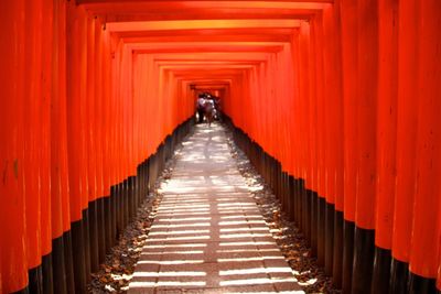 Orange structures called tori lined up forming a pathway in fushimi inari shrine in kyoto, japan