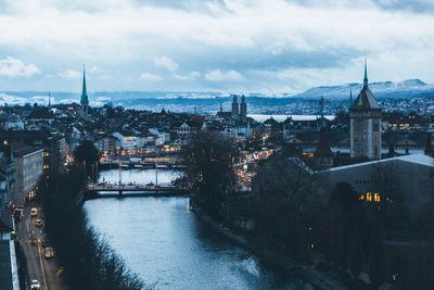 Aerial view of zurich city center at dawn, with the limmat river in the foreground.