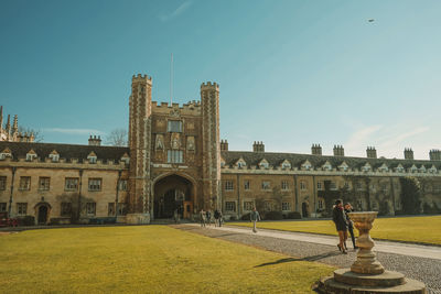 Woman standing by historic building against sky