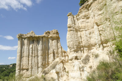 Low angle view of rock formation against sky