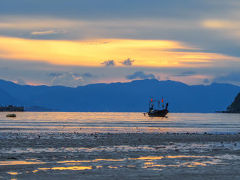 Silhouette boat in sea against sky during sunset
