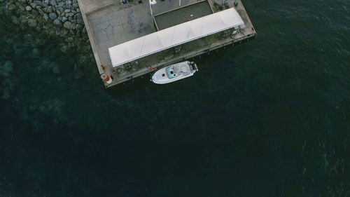 High angle view of boat moored in sea by jetty