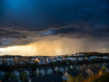 The sun-rays and dark clouds create a dramatic scene over a us neighborhood before a bad weather.