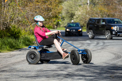 Gurl with pedal car on road