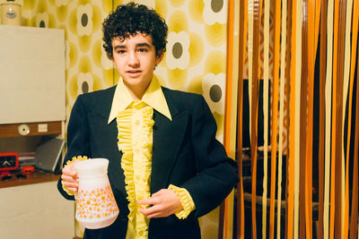 Portrait of boy wearing suit standing at home