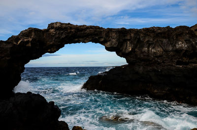 Scenic view of sea and rock formation against sky