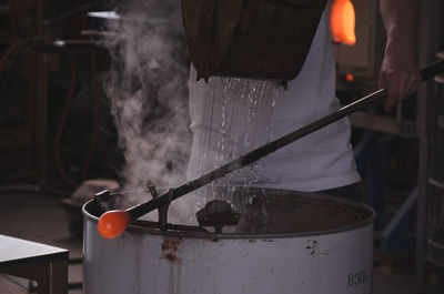 Close-up of man working in glass factory