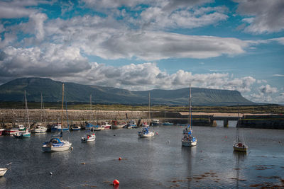 Boats moored in sea against sky