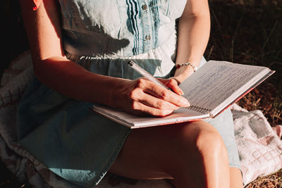 Midsection of woman reading book