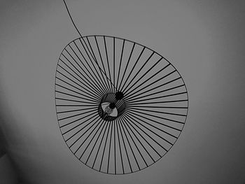 Low angle view of electric lamp hanging on ceiling