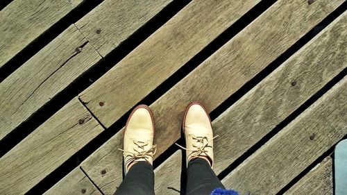 Low section of person standing on wooden floor