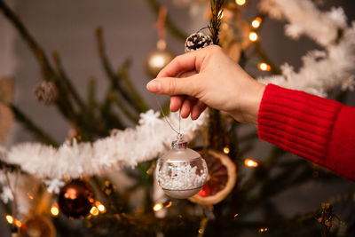 Close-up view while decorating a live christmas tree for christmas.