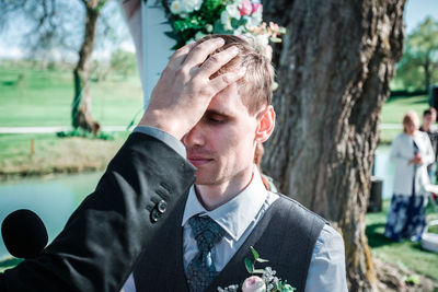 Portrait of young man against tree trunk