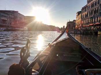 Canal amidst city against sky during sunset