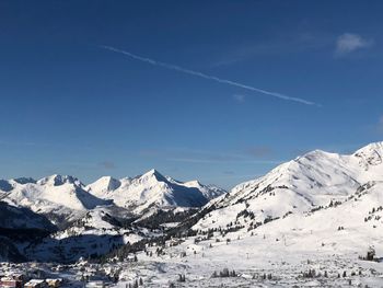 Scenic view of snowcapped mountains against blue sky