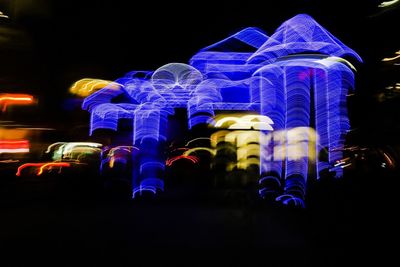 Low angle view of illuminated christmas lights against sky at night