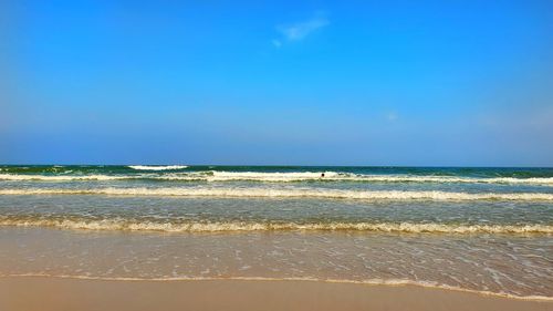 Scenic view of beach against blue sky