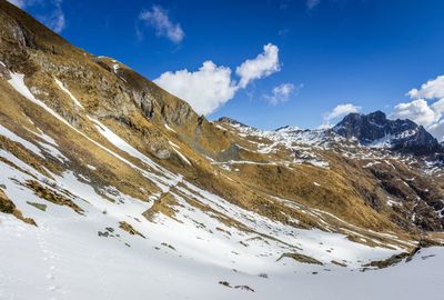 Scenic view of mountains against blue sky during winter