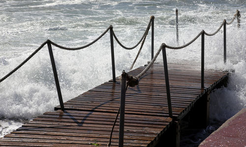 Railing by sea against sky