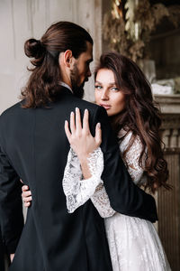 Young couple standing against wall