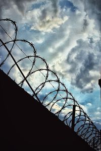 Low angle view of barbed wire against sky