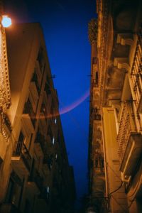 Low angle view of illuminated buildings against sky at night