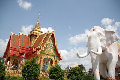 Low angle view of sculpture and temple against sky