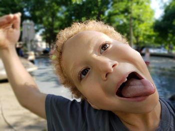 Close-up portrait of cute girl holding camera