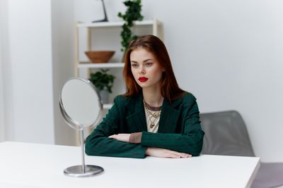 Portrait of young woman using digital tablet while sitting at home