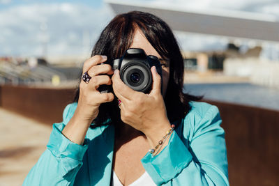 Young woman photographing with camera