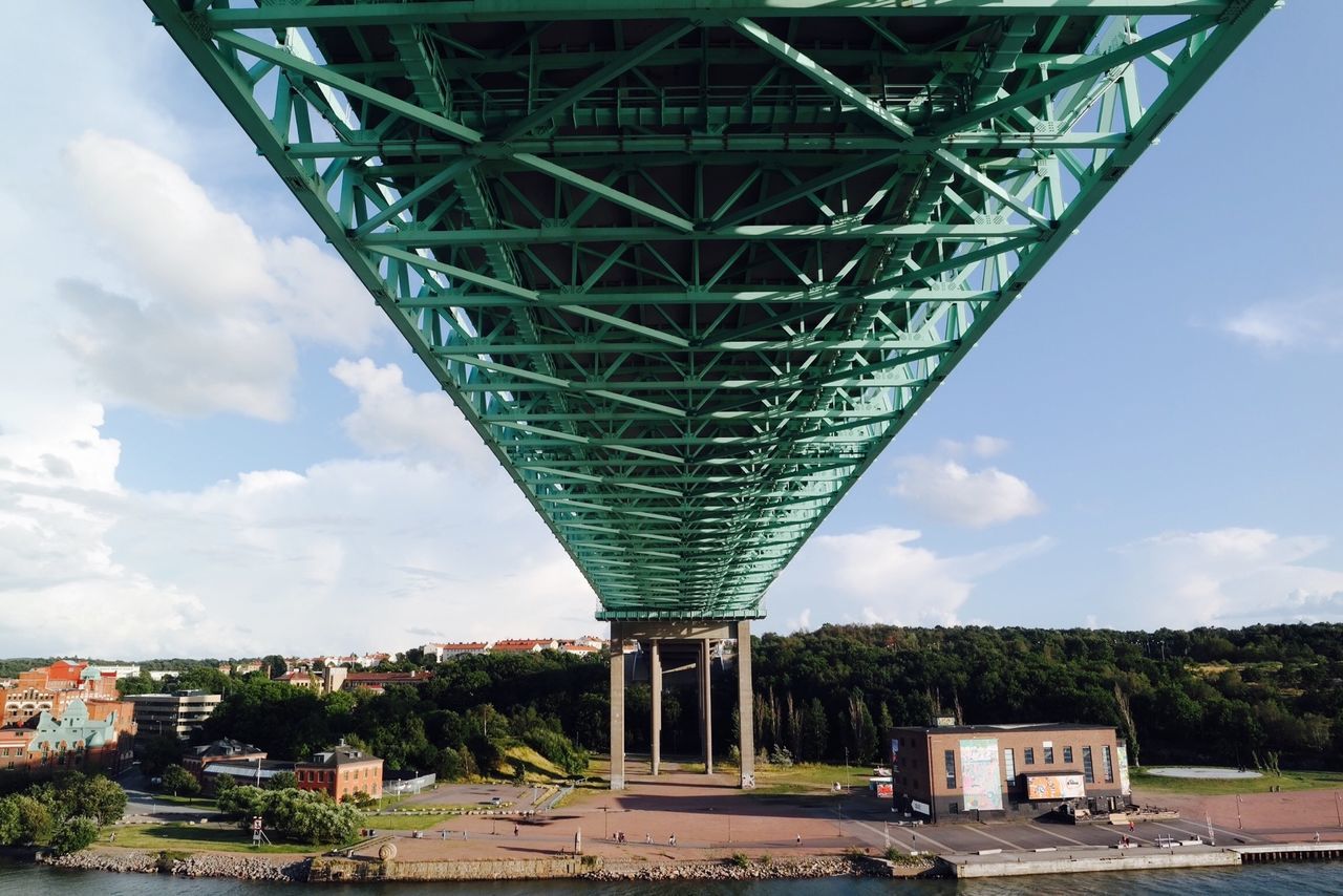 architecture, built structure, connection, bridge - man made structure, sky, transportation, engineering, metal, tree, metallic, cloud - sky, low angle view, bridge, building exterior, day, road, outdoors, no people, cloud, railway bridge