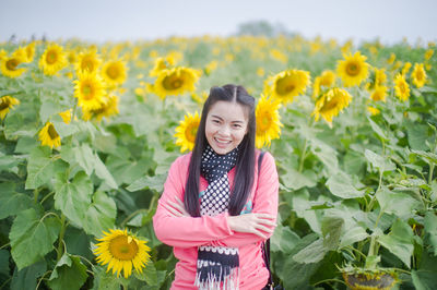 Portrait of woman standing on sunflower field