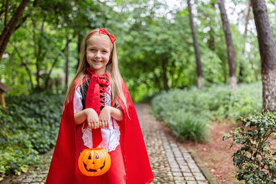 Portrait of smiling girl wearing costume standing at park