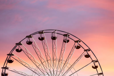 Low angle view of ferris wheel against sky at sunset