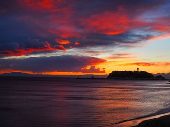 Scenic view of sea against dramatic sky during sunset